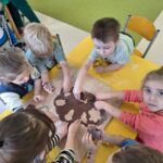 Dzieci z grupy Niedźwiadki wykrawają pierniczki w różnych kształtach