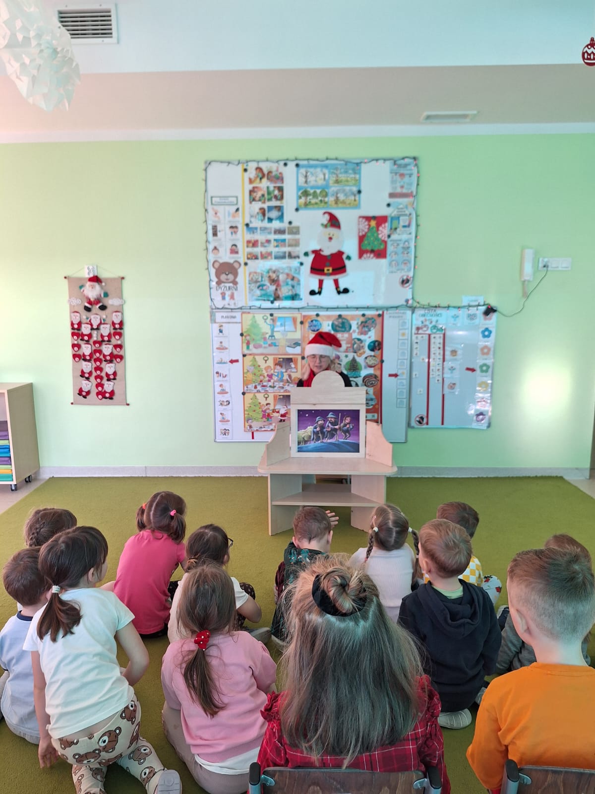 Pani Asia z Miejsko-Powiatowej Biblioteki Publicznej – filii nr 3 w Lublińcu, przedstawia dzieciom teatrzyk Kamishibai