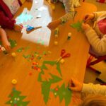 Dzieci w trakcie ozdabiania wyciętej wcześniej choinki