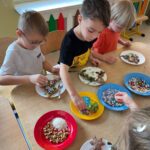 Dzieci z grupy Pszczółki ozdabiają pierniczki w różnymi kolorowymi posypkami