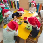 Dzieci z grupy krasnoludki ozdabiają pierniczki różnymi kolorowymi posypkami