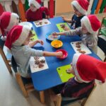 Dzieci z grupy krasnoludki ozdabiają pierniczki różnymi kolorowymi posypkami