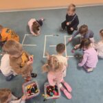 Dzieci tworzą napis LEGO z klocków