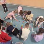 Dzieci tworzą napis LEGO z klocków