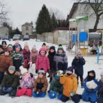 Dzieci pozują podczas zabaw na śniegu
