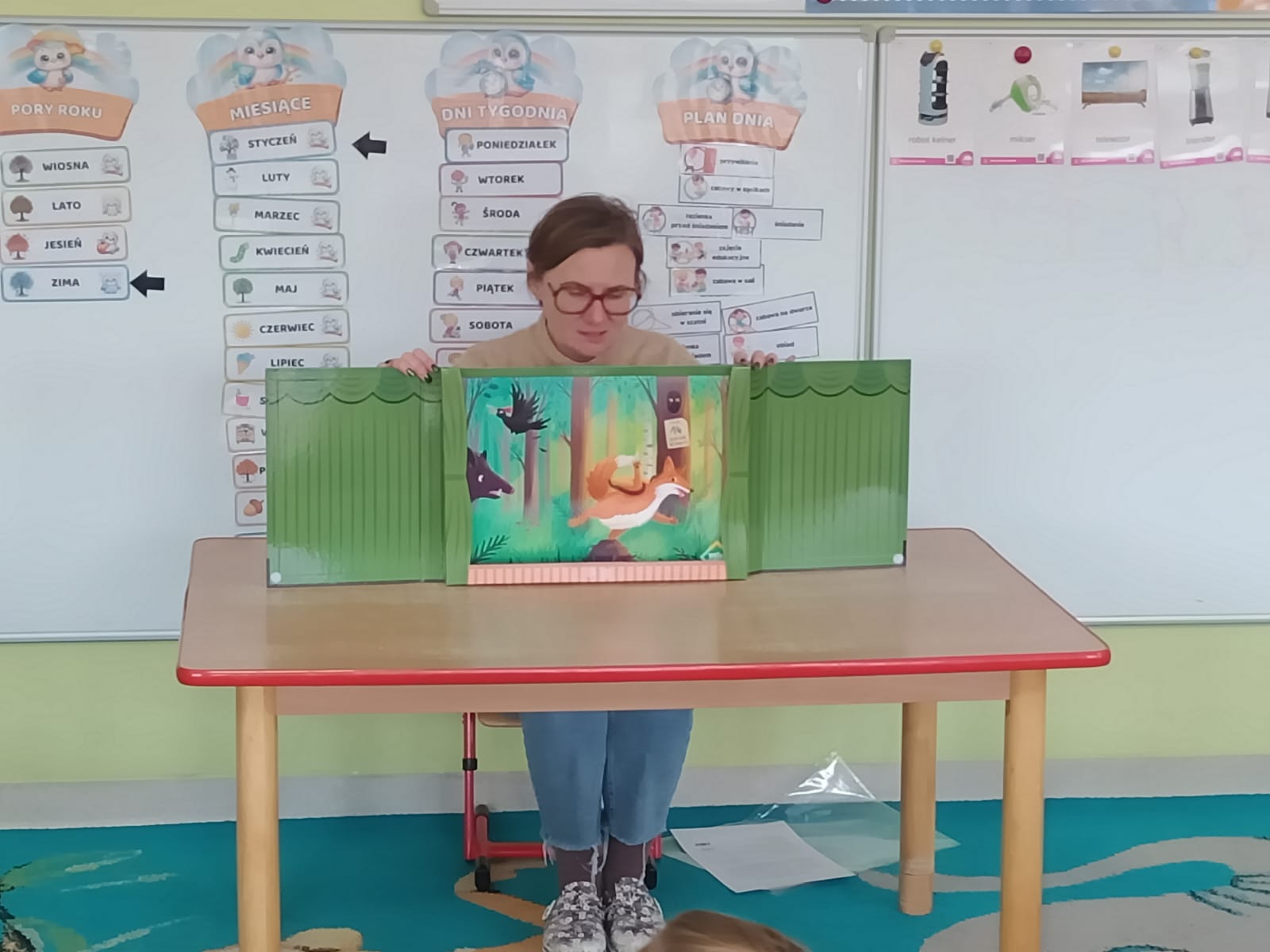Nauczyciel czyta dzieciom opowiadanie „O Nieśmiałym kreciku Bartku”