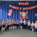 Dzieci składają swoim babciom i dziadkom życzenia wraz ze swoimi "podarunkami"