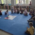 Dzieci uważnie słuchają opowieści dotyczącej kolejnej muzyczno-ruchowej zabawy