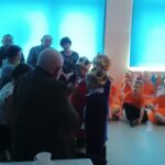 Babcie i dziadkowie oglądają występ wnuków z okazji ich święta