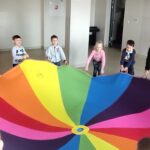 Dzieci podczas zabawy muzyczno-ruchowej z chustą animacyjną