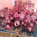 Dzieci z grupy Mądre Sowy delektują się popcornem oglądając bajkę