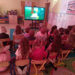 Dzieci z grupy Mądre Sowy delektują się popcornem oglądając baję