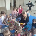 Dzieci w trakcie rozpakowywania magicznej skrzyni z instrumentami muzycznymi