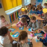 Dzieci z grupy Pszczółki wykonują pracę plastyczną, układają bałwanka według wzoru