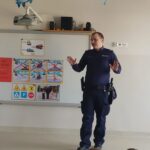 P. policjant z Komendy Miejskiej w Lublińcu opowiada dzieciom jak zachować ostrożność podczas ferii zimowych.