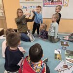 Dzieci przyglądają się budowie i długości piór ptaków