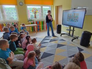 Dzieci z grupy Mądre Sowy uczestniczą w zajęciach dotyczących świadomości o Autyzmie- słuchają bajki.