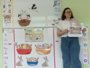 Pani Oliwia czyta dzieciom bajkę wraz z grafikami.