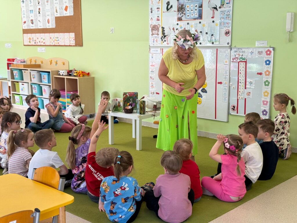 Dzieci uczestniczą w spotkaniu z bibliotekarką.