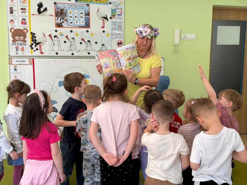Dzieci uczestniczą w spotkaniu z bibliotekarką.