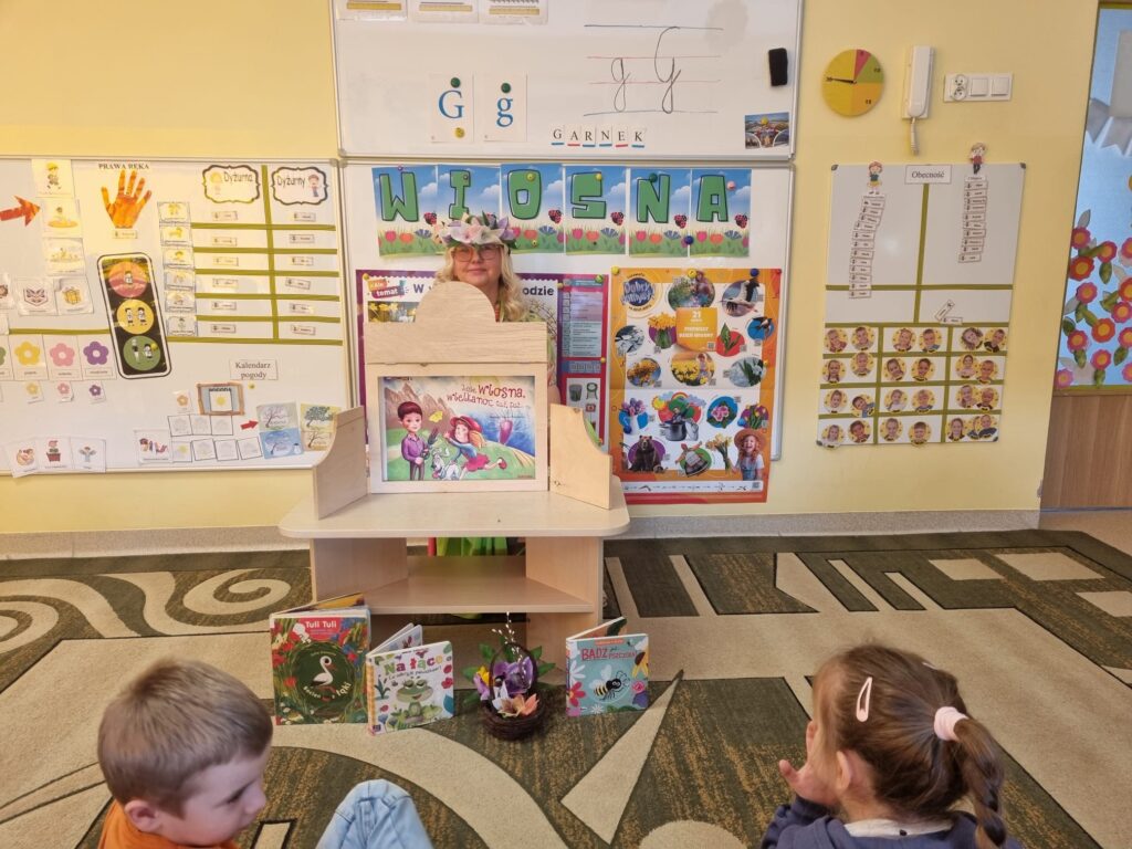 Dzieci uczestniczą w spotkaniu z bibliotekarką.