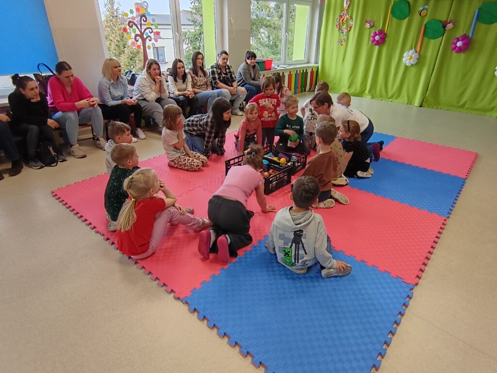 Dzieci wraz z rodzicami biorą udział w matematycznych zajęciach otwartych.