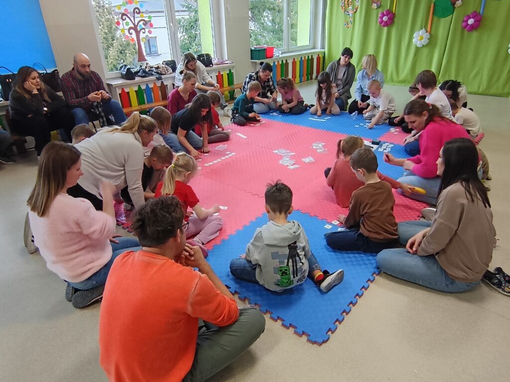 Dzieci wraz z rodzicami biorą udział w matematycznych zajęciach otwartych.