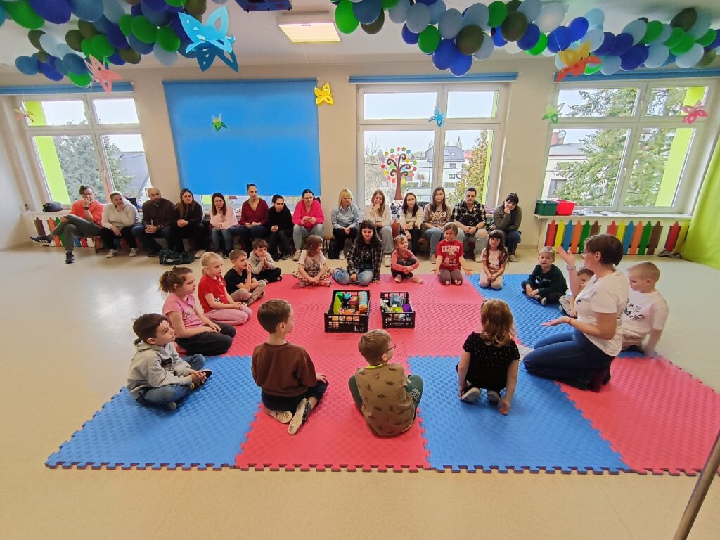 Dzieci wraz z rodzicami biorą udział w matematycznych zajęciach otwartych.