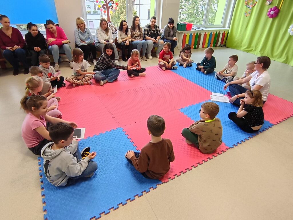 Dzieci wraz z rodzicami biorą udział w matematycznych zajęciach otwartych.