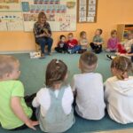 Dzieci słuchają bajeczki czytanej przez gościa