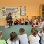 Dzieci słuchaja bajeczki czytanej przez gościa- pt. "Mysz miejska i mysz wiejska"