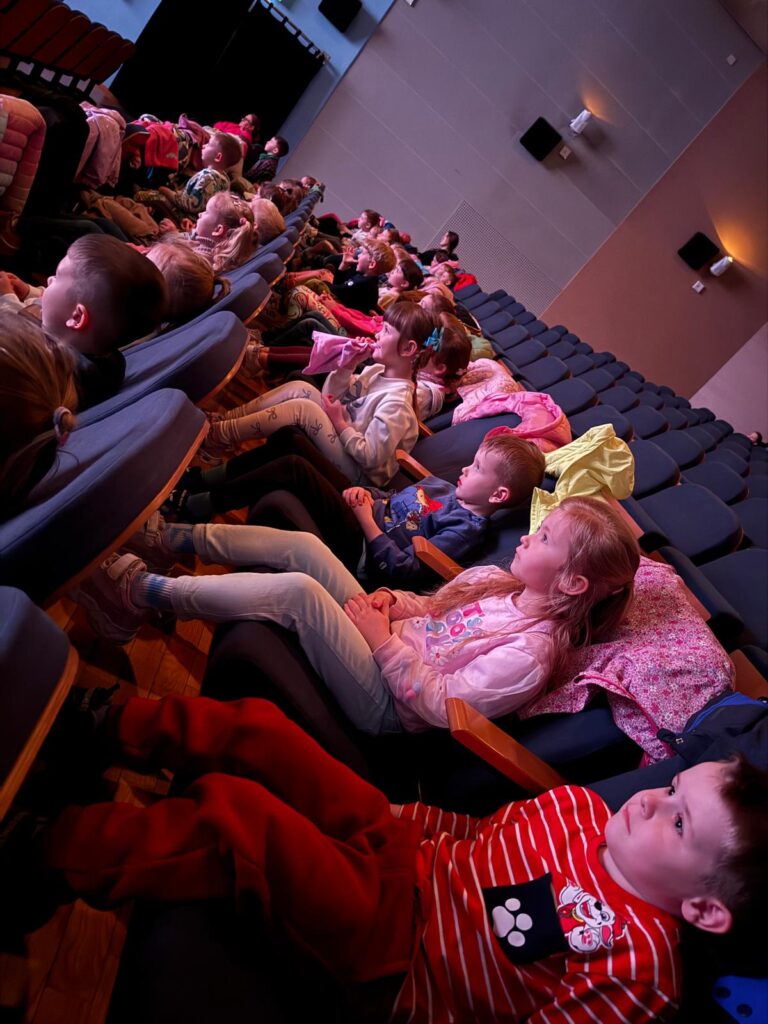 Dzieci siedzą na widowni