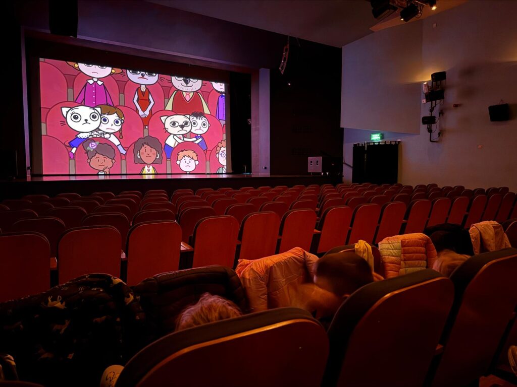 Dzieci siedzą na widowni