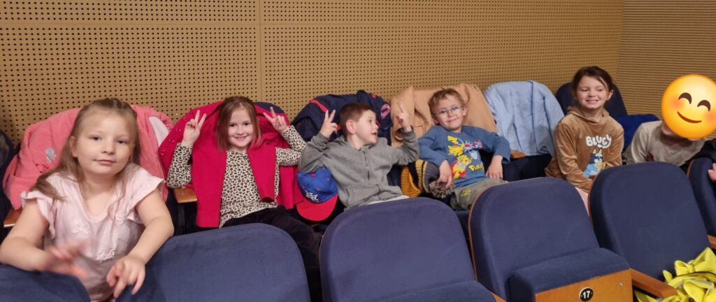 Dzieci siedzą na widowni