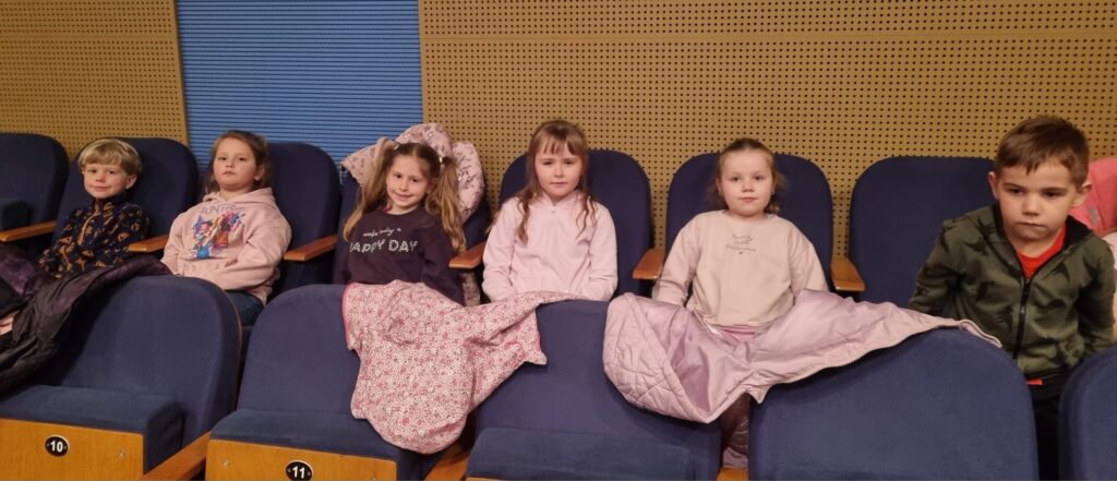 Dzieci siedzą na widowni