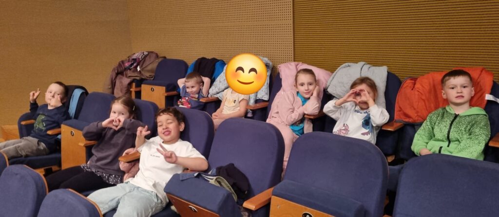 Dzieci siedzą na widowni