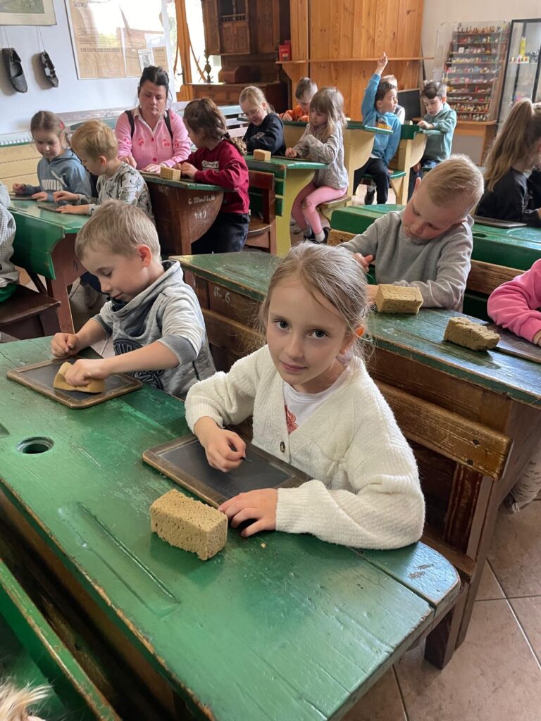 Dzieci siedzą w dawnej szkole.