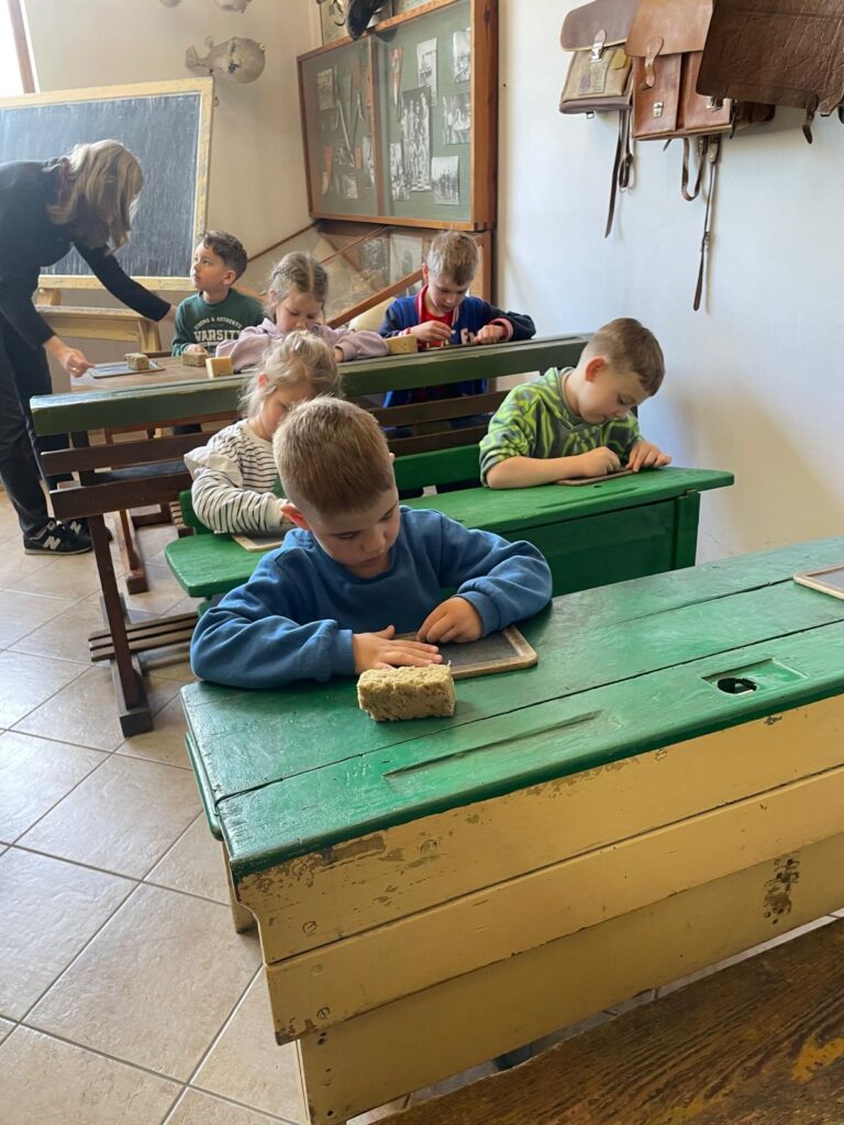 Dzieci siedzą w dawnej szkole.
