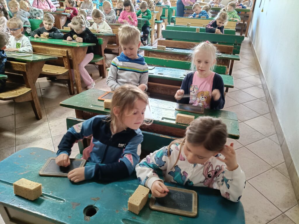 Dzieci siedzą w dawnej szkole.