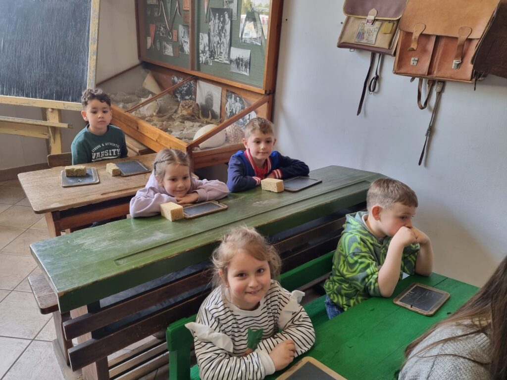 Dzieci siedzą w dawnej szkole.