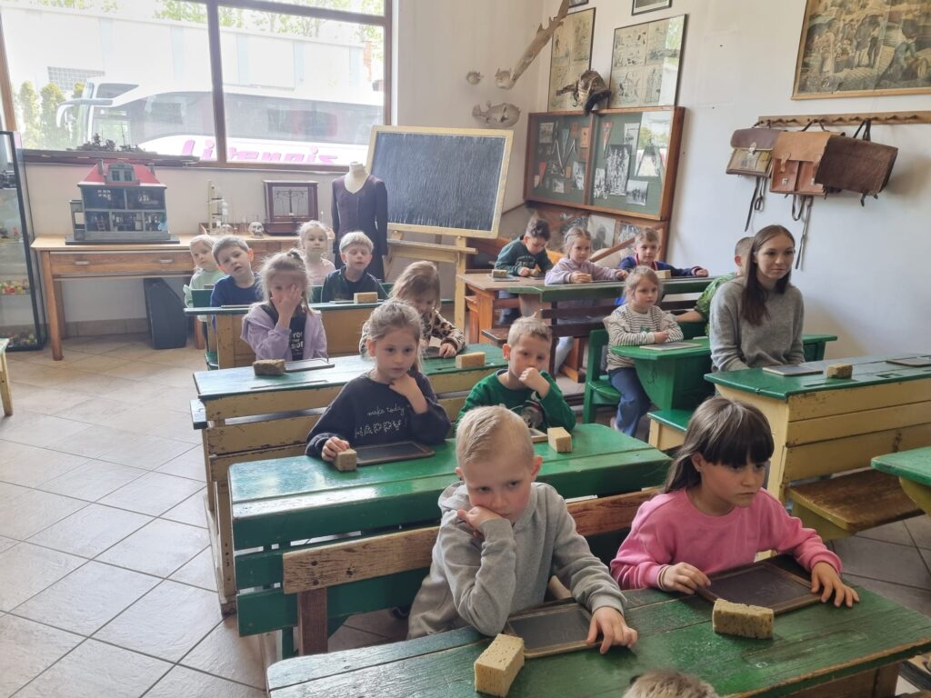 Dzieci siedzą w dawnej szkole.
