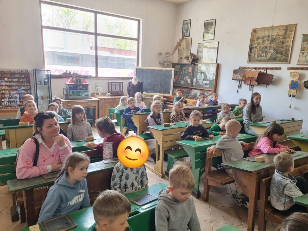 Dzieci siedzą w dawnej szkole.