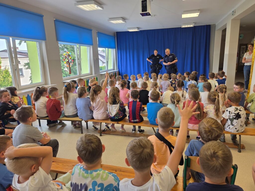 Dzieci uczestniczą w spotkaniu z policjantami.