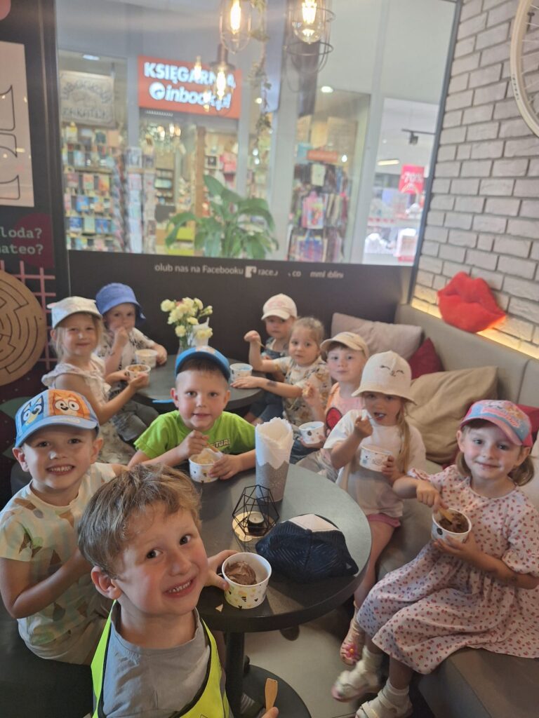 Dzieci odwiedziły kawiarnie jedzą lody.