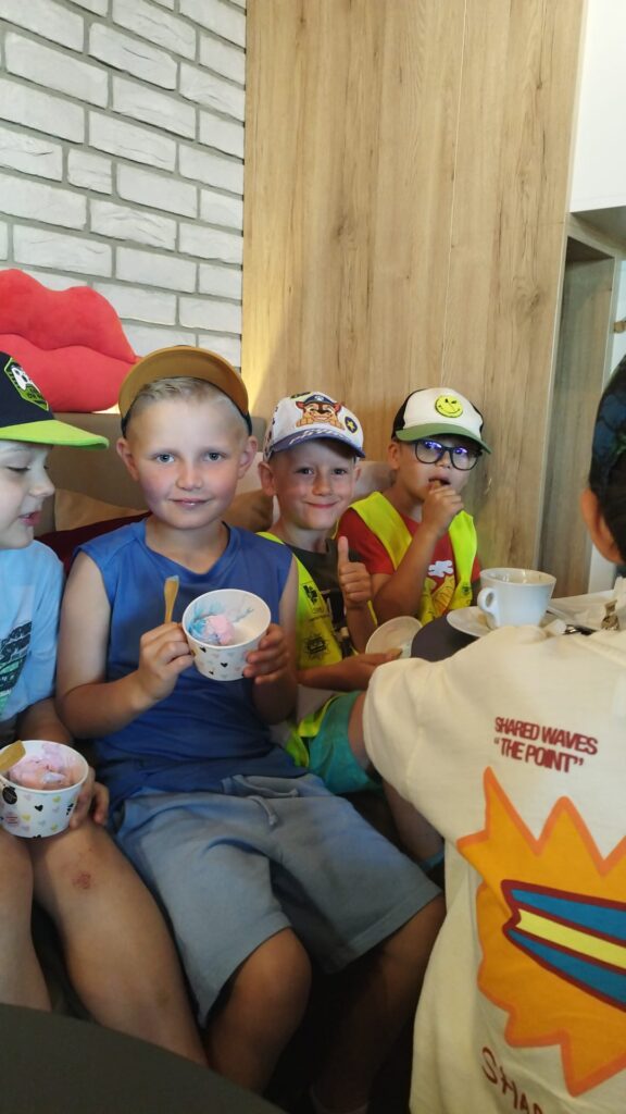 Dzieci odwiedziły kawiarnie jedzą lody.