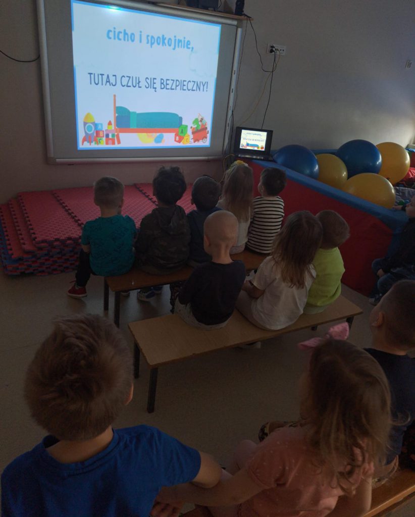 dzieci oglądają prezentacje multimedialną na rzutniku