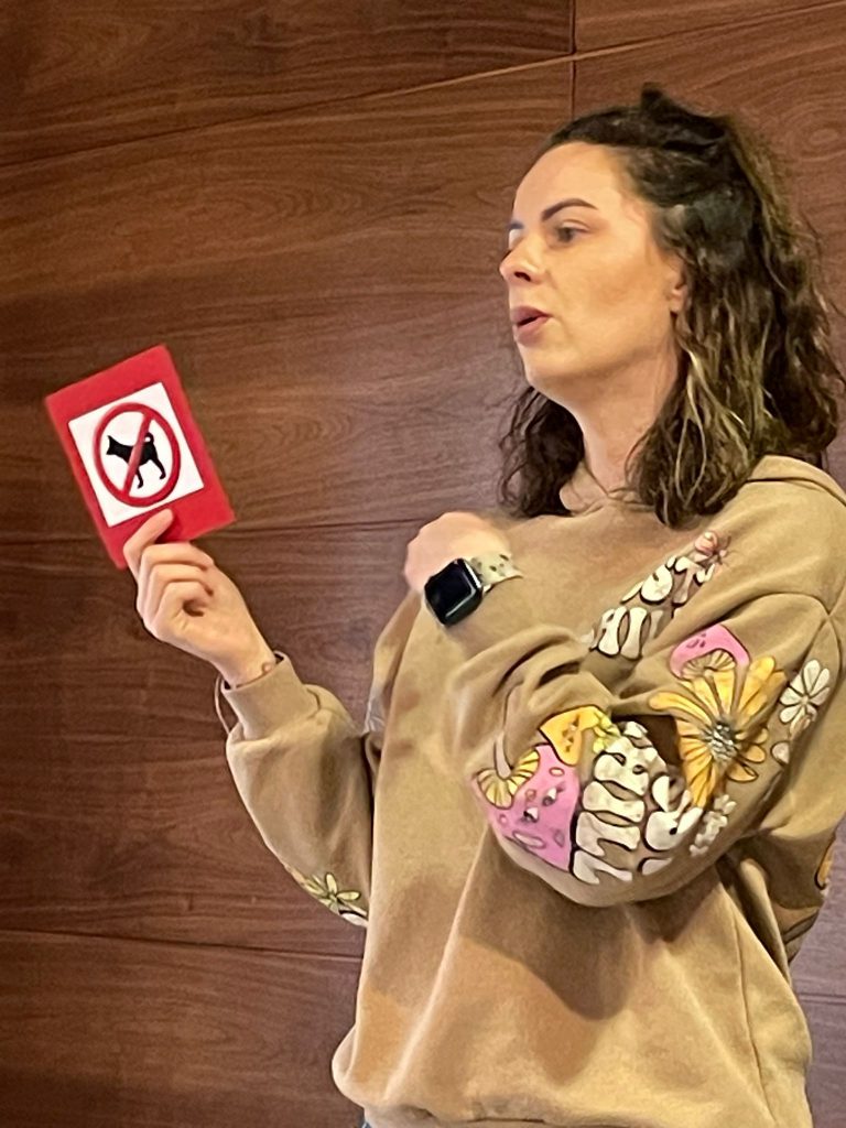 Kobieta pokazuje znak zakaz wprowadzania zwierząt. 