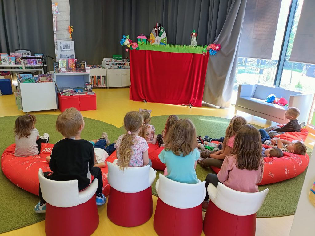 Dzieci oglądają przedstawienie w bibliotece.